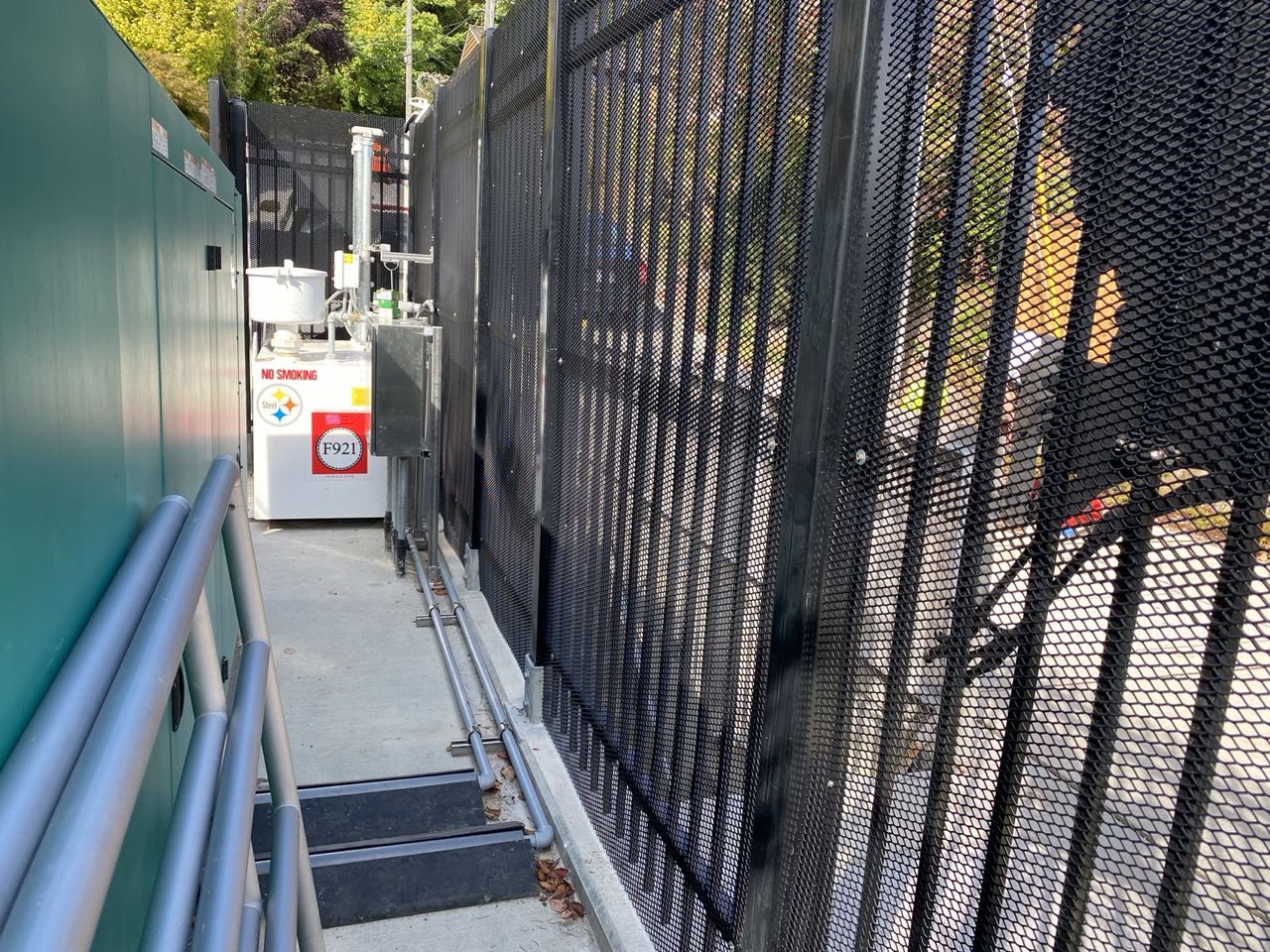 Expanded-metal security screen fence around utility equipment