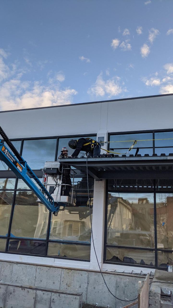 Crew installing a fabricated steel canopy on a storefront